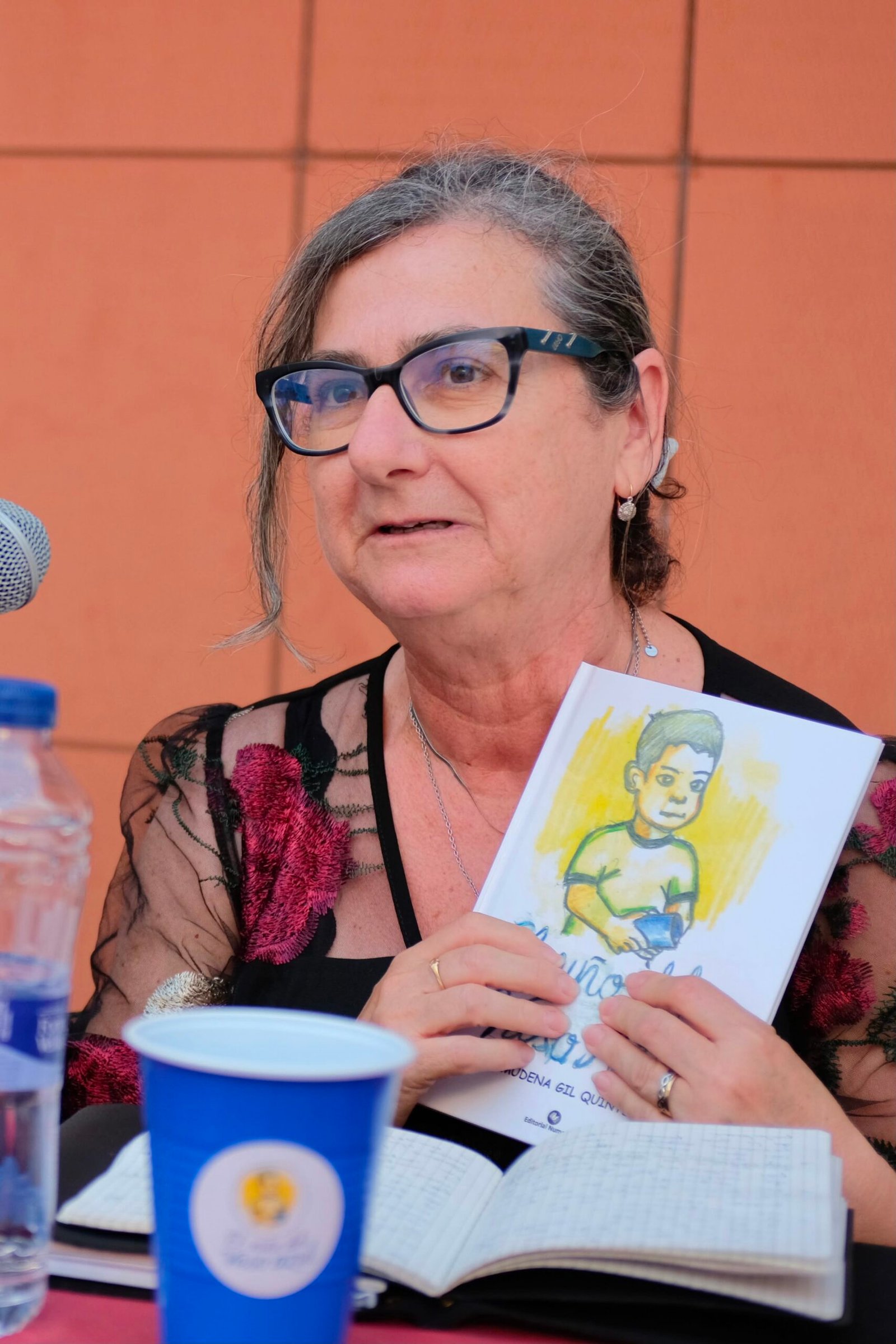 EN LA IMAGEN APARECE LA AUTORA ALMUDENA GIL SUJETANDO EN SUS MANOS SU LIBRO "EL NIÑO DEL VASO AZUL"